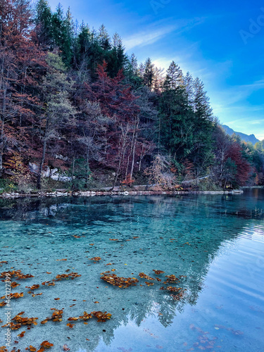 clear lake in the mountains and colorful forest and blue sky in the background