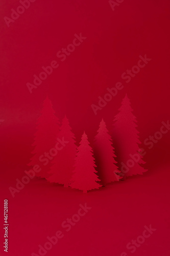 Christmas creative concept. Red Christmas tree of paper on the red background. Holiday concept.