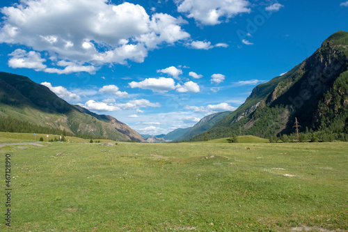 peaks of mountains against a blue sky with white clouds. Summer clear sunny day