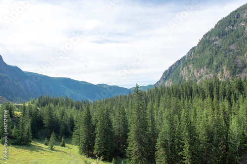 peaks of mountains against a blue sky with white clouds. Summer clear sunny day