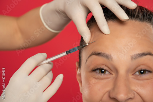 Portrait of a young smiling woman on a face filler injection procedure