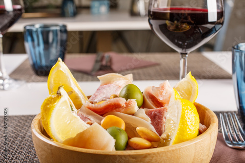 Piede di maiale e muso di vitello depilati, bolliti, raffreddati, tagliati in piccoli pezzi e serviti freddi, conditi con sale, succo di limone, olive e lupini photo