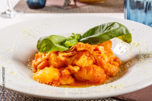 Interiora di maiale cotte con patate e sugo di pomodoro con basilico per decorazione servite in un ristorante photo