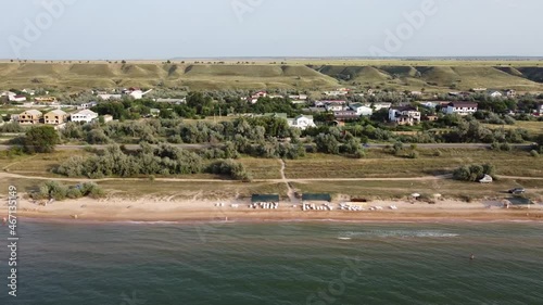 Aerial view of sandy beach during golden hour. Tracking shot, right to left.