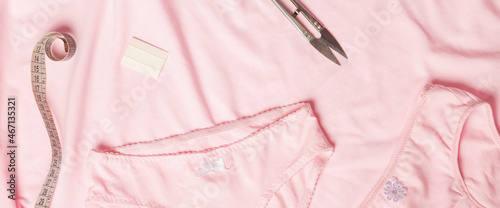 pink women's panties lie on a rumpled table background, underwear. sewing underwear. seamstress workplace.
