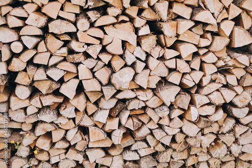 Natural wooden background - close up of chopped firewood. Firewood stacked and prepared for winter Pile of wood logs.