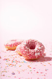 Donuts with pink icing and sugar sprinkle  on pink background