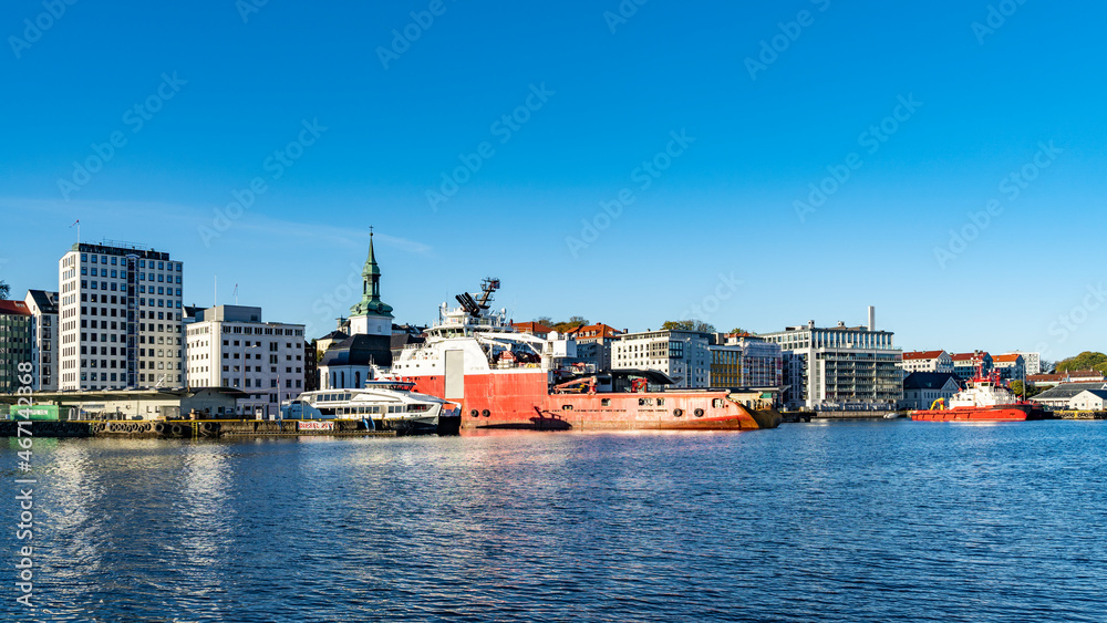 Naklejka premium Im Hafen von Bergen, Norwegen, mit Blick auf die Stadt mit ihren Häusern, den Hafenanlagen und Schiffen. sonniger Tag beim Stadtrundgang.