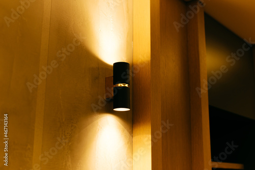 Tableau sur toile Warm black lamp on a beautiful wooden wall. Indirect light.