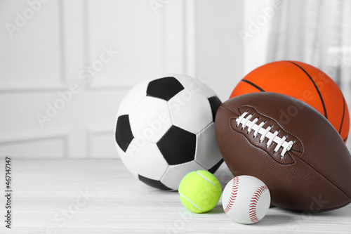 Set of different sport balls on white wooden table indoors. Space for text