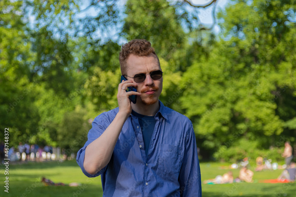 a man is talking on the phone in the park