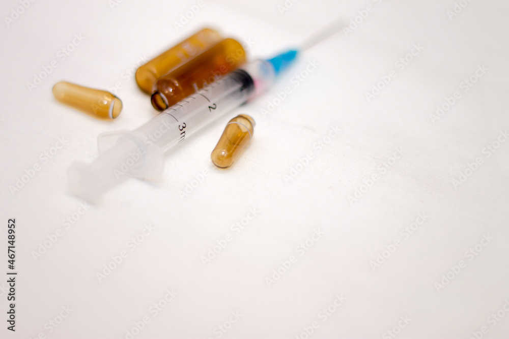 Empty medical ampoules infusion and used syringe after vaccination isolated on white background