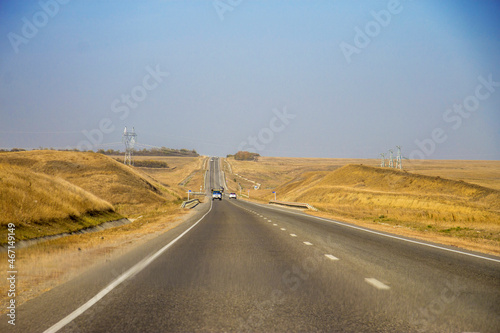 Road and moving cars at daytime and blue sky over