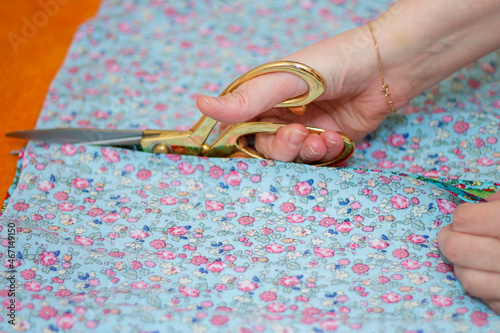 Woman cutting the colorful facbric in workshop