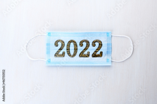 Medical mask with numbers 2022 Tiger on white wooden background. Coronavirus infection control concept. Symbol 2022 Tiger .