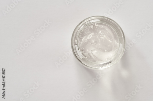 Aloe vera gel in a glass jar on white background, top view. Natural skin moisturizer.