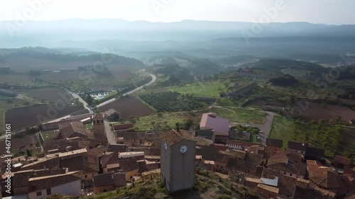 A 360 degrees spiral drone view over the clock tower on top of the hill in Monroyo, Spain photo