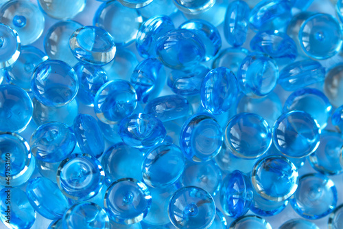 Transparent blue glass marble beads. Acrylic ice stones for decoration. Water drops background. Abstract wallpaper or backdrop for web design