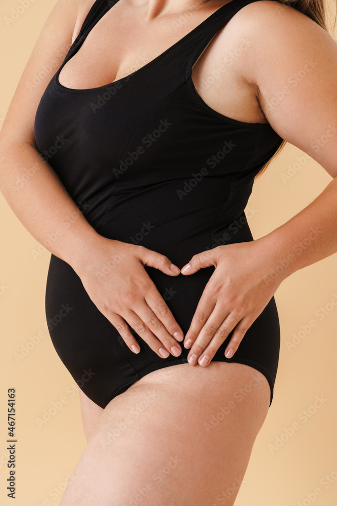 Fototapeta premium Young woman wearing black swimsuit showing her hip