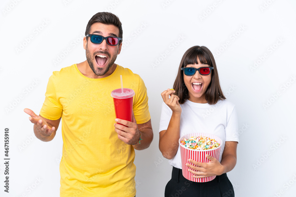 Young couple isolated on white background with 3d glasses and holding a big bucket of popcorns