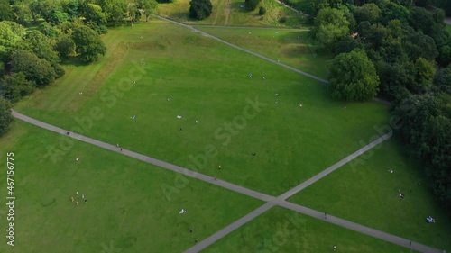 green lawn in park, people relaxing in nature. Tilt up reveal of Greenwich Observatory. London, UK photo
