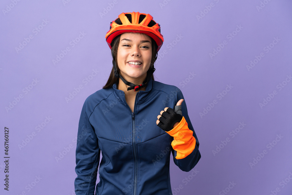 Teenager cyclist girl pointing to the side to present a product