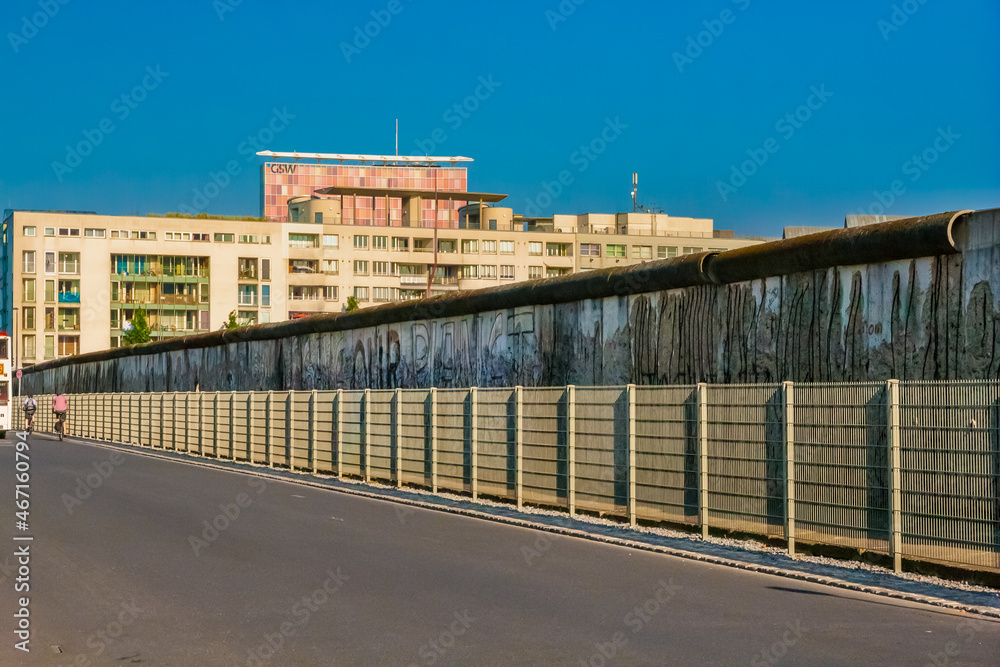Great view of the popular street Niederkirchnerstraße with a preserved section of the Berlin Wall in the background in Berlin, Germany, on a nice sunny day with a blue sky. Great view of the popular street Niederkirchnerstraße with a preserved section of the Berlin Wall in the background in Berlin, Germany, on a nice sunny day with a blue sky.