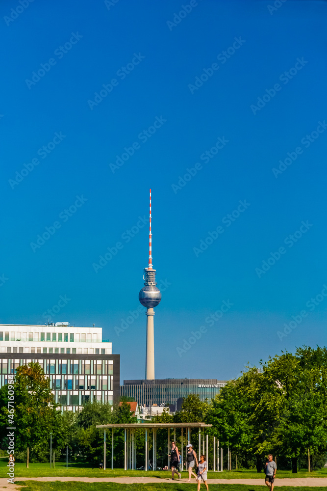 Beautiful view of the Berlin Television Tower (Berliner Fernsehturm) with its impressive sphere and spire in the background of the capital city in Germany on a nice sunny summer day with a blue sky.