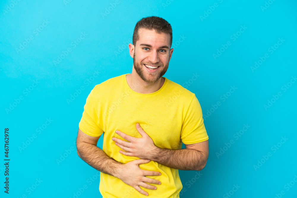 Young handsome caucasian man isolated on blue background smiling a lot Young handsome caucasian man isolated on blue background smiling a lot