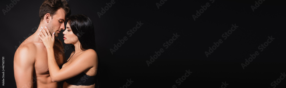 sexy woman touching face of shirtless man isolated on black, banner sexy woman touching face of shirtless man isolated on black, banner