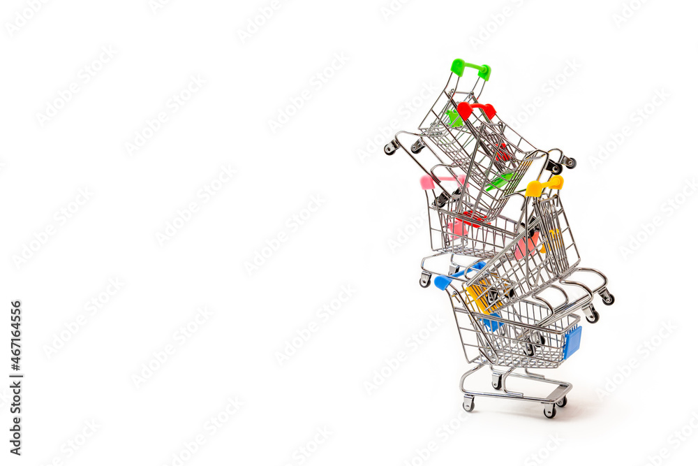 Grocery carts are stacked high on top of each other. Iron miniature supermarket trolley are heaped up. The concept of sales, shopping in stores, discounts. Isolate on  white background. Place fo
