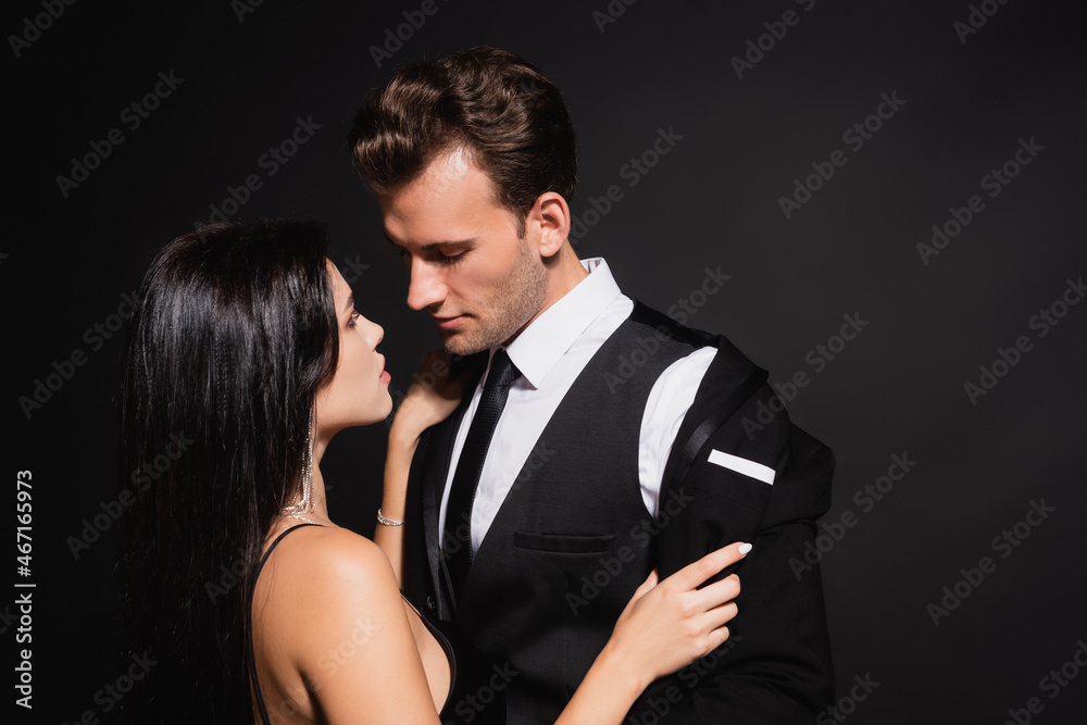 passionate woman undressing man in elegant suit isolated on black passionate woman undressing man in elegant suit isolated on black