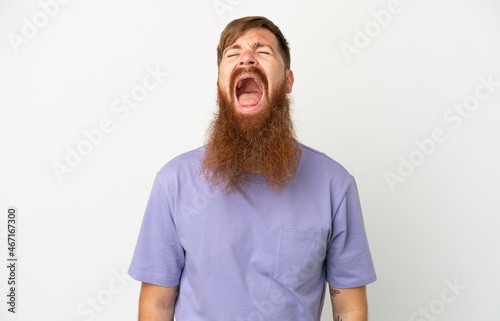 Young reddish caucasian man isolated on white background shouting to the front with mouth wide open