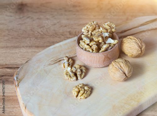 Bowl with delicious walnuts on a wooden table
