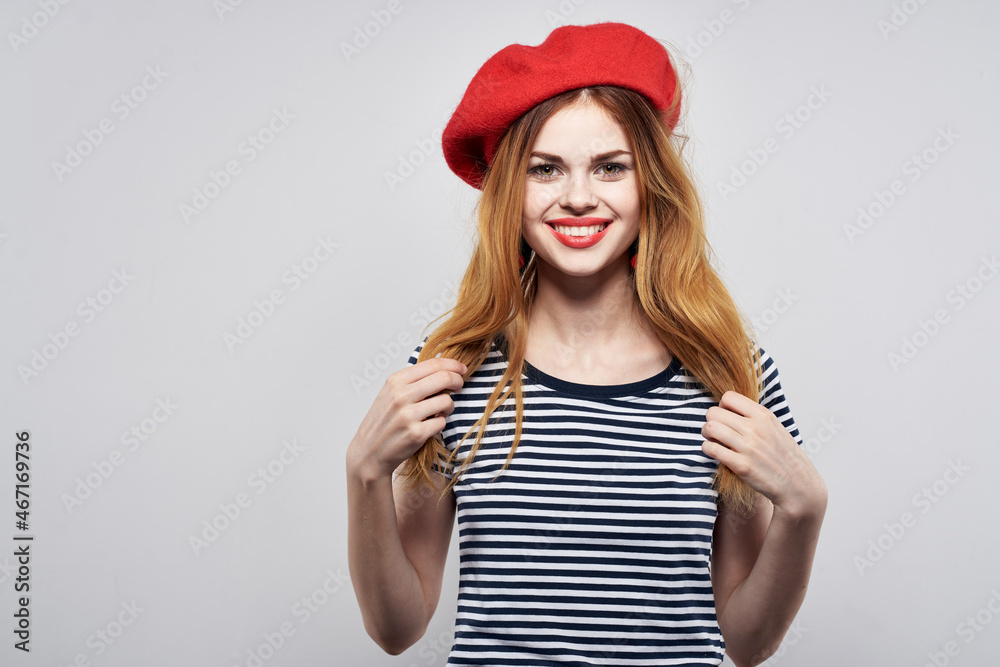 cheerful woman in a striped t-shirt red lips gesture with his hands model studio cheerful woman in a striped t-shirt red lips gesture with his hands model studio