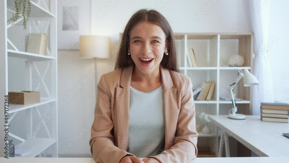 Excited woman. Online conference. Winner joy. Happy lady expressing euphoric emotion having video call in light room interior. Excited woman. Online conference. Winner joy. Happy lady expressing euphoric emotion having video call in light room interior.