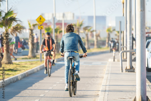 latin man riding a bicycle on bikeway at sunset in La Serena