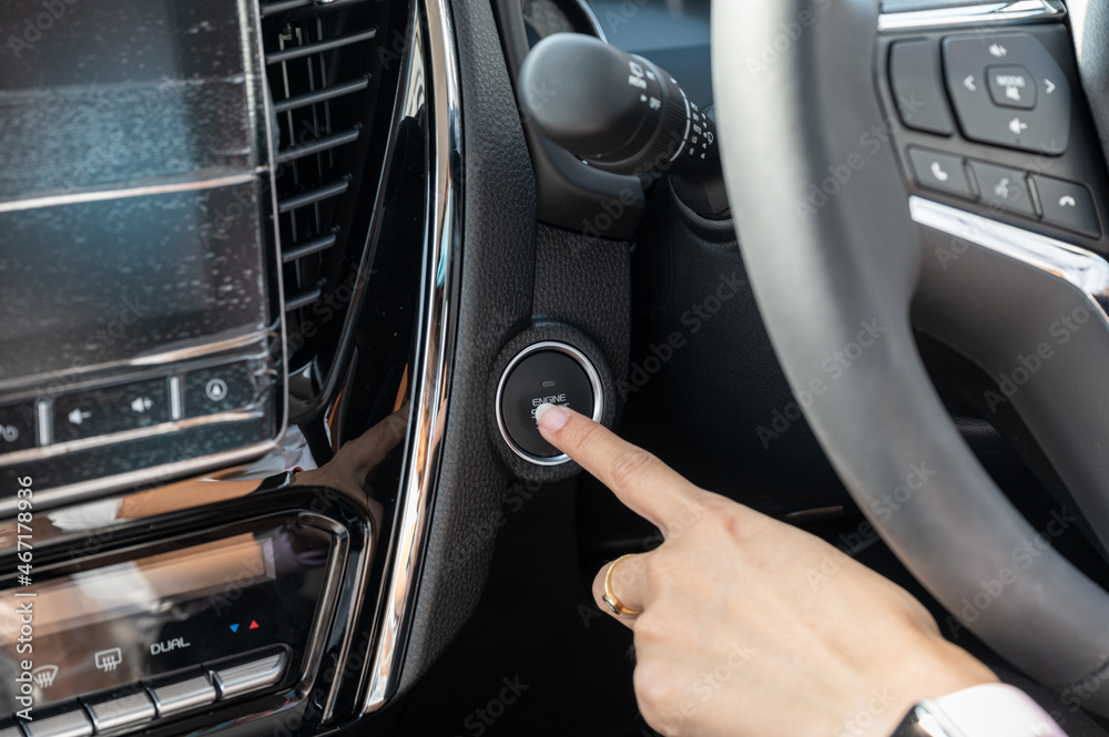Finger pushing on engine start botton in modern car Finger pushing on engine start botton in modern car