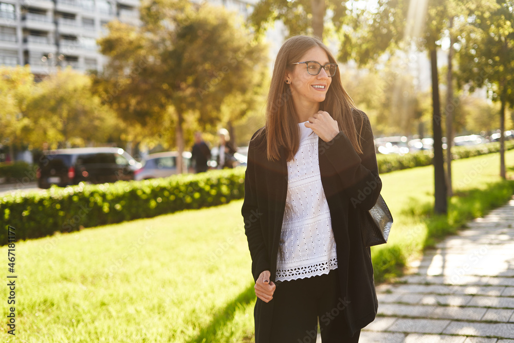 Happy woman standing on park near residential buildings Happy woman standing on park near residential buildings