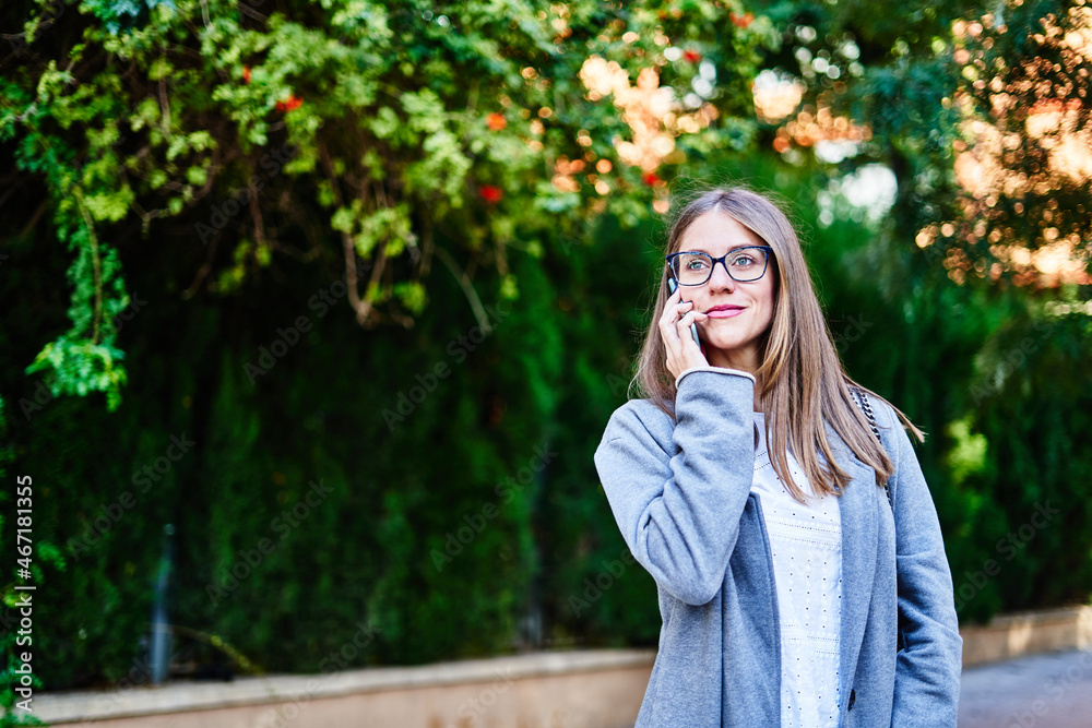 Woman talking on smartphone on sidewalk