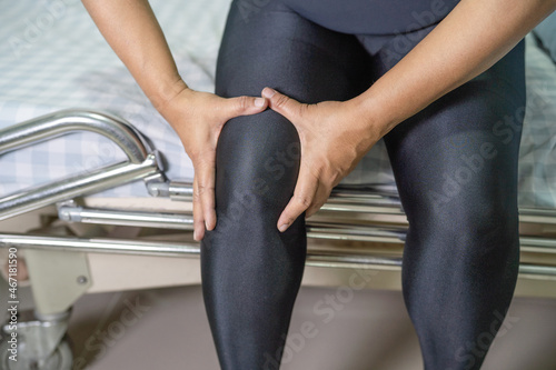 Asian middle-aged lady woman patient touch and feel pain her knee, healthy medical concept. photo