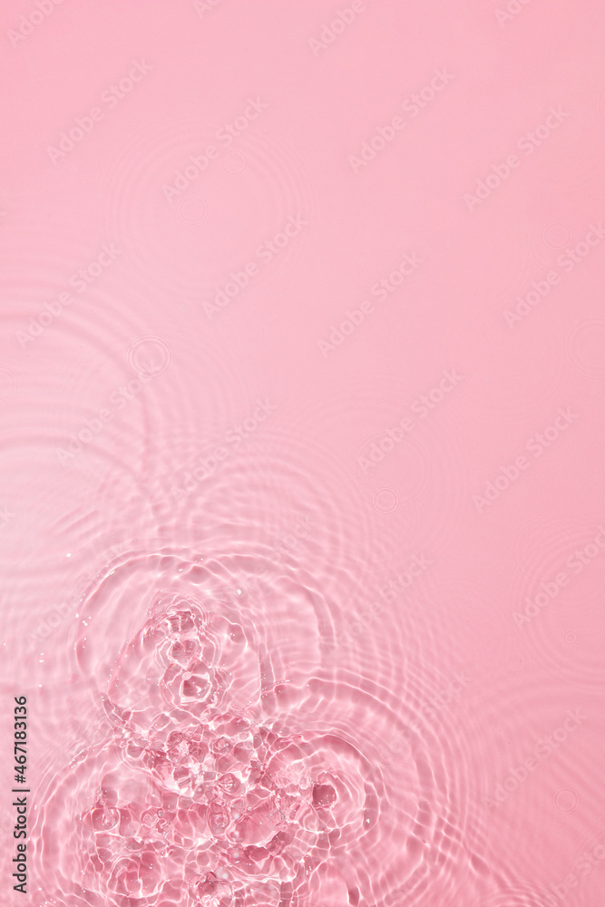 Transparent pink colored clear water surface texture with ripples, splashes and bubbles. Abstract nature pink background Water waves in sunlight with blank space for cosmetic advertising Transparent pink colored clear water surface texture with ripples, splashes and bubbles. Abstract nature pink background Water waves in sunlight with blank space for cosmetic advertising