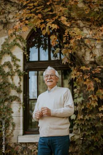 Senior man standing by the window at the autumn day © BGStock72