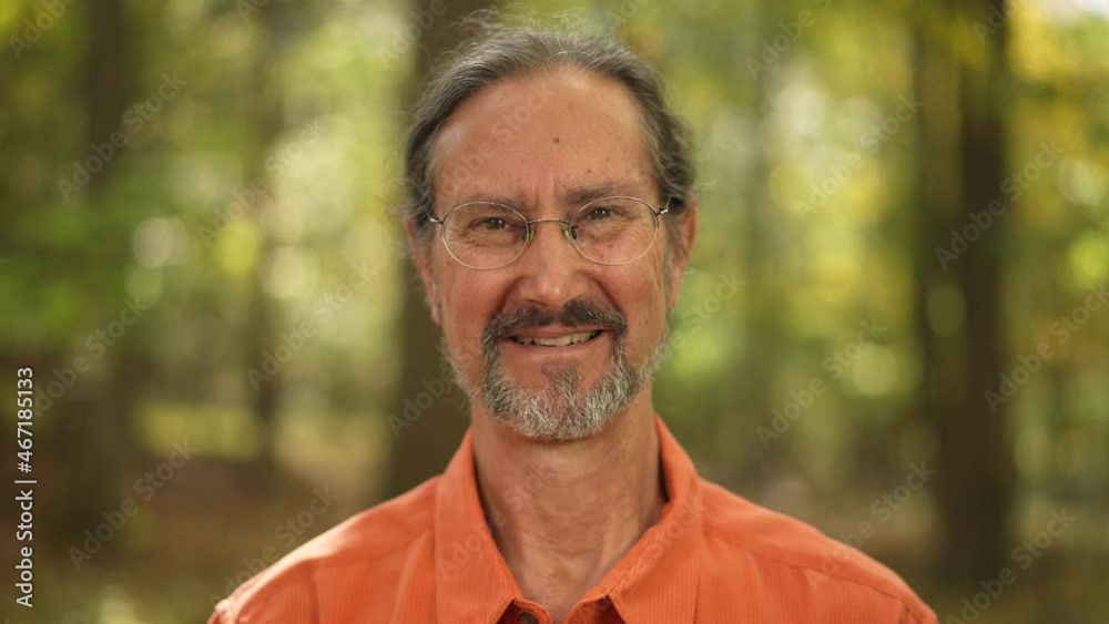 Portrait of ethnic, mature man with glasses happy and smiling with green background.