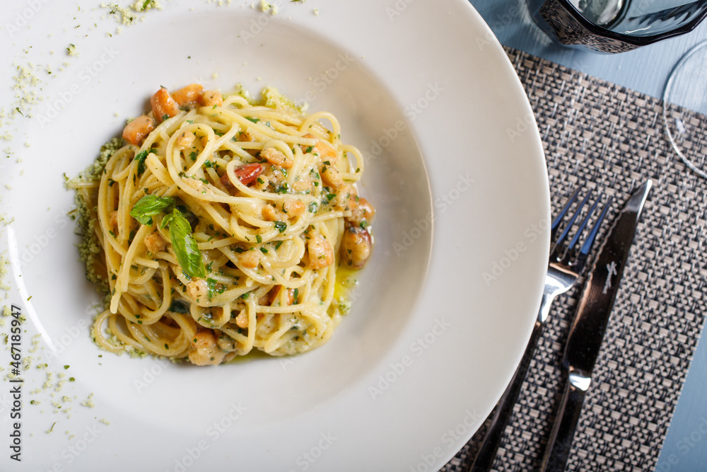 Spaghetti con aglio, olio, prezzemolo e tarallo sbriciolato serviti in un ristorante