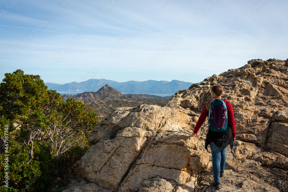 young woman alone walking in the corsican countryside looking at the view, concept of adventure holidays traveling alone.