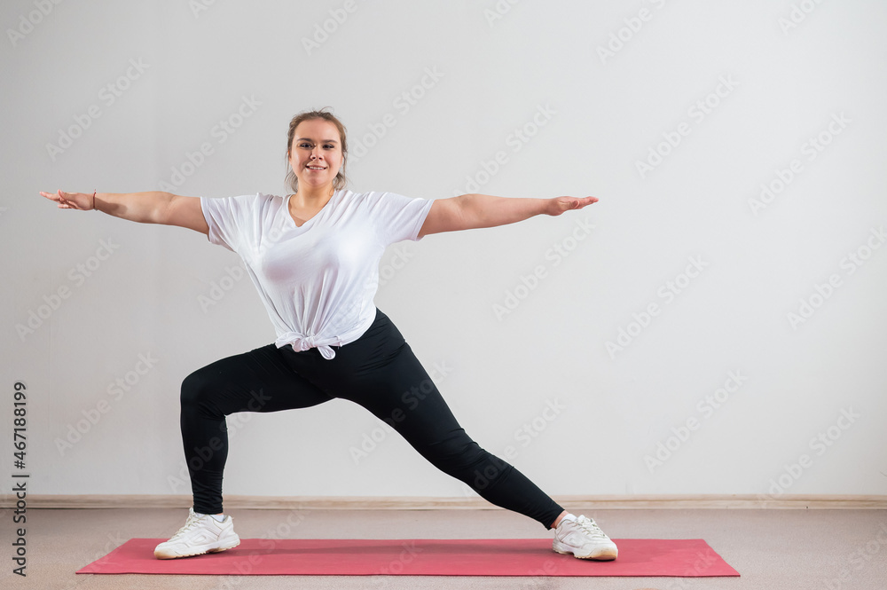 Young fat woman doing flexibility exercises on a white background