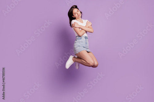 Portrait of inspired carefree girlish relaxed lady jump embrace shoulders love concept on purple background