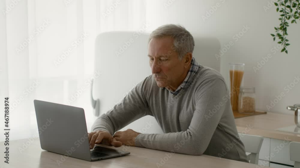 Remote Work On Retirement. Focused Senior Man Working With Laptop At Home Remote Work On Retirement. Focused Senior Man Working With Laptop At Home