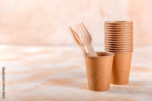 Eco-friendly disposable paper tableware. Paper cup, wooden forks, recycling or green concept. copy space